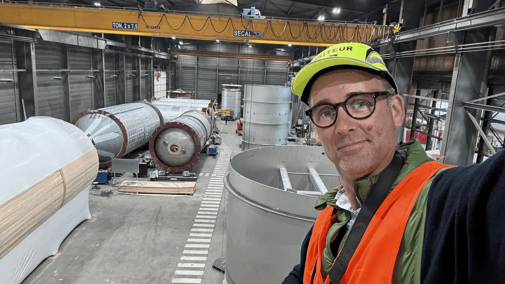 Olivier Van Meyel en immersion dans l'atelier d'un client industriel, casque visiteur et gilet de sécurité